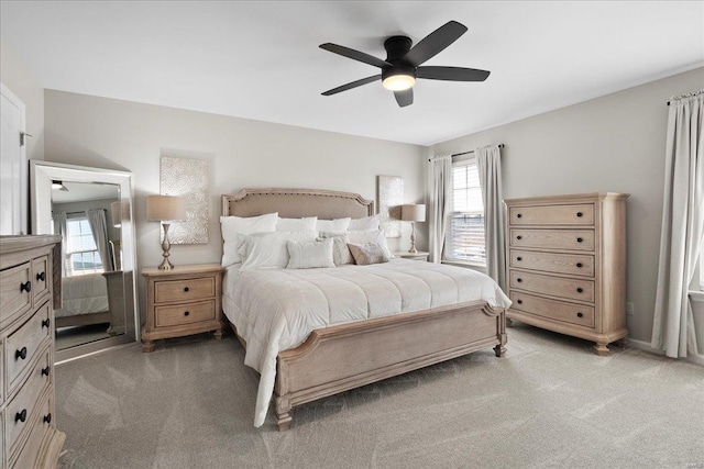 bedroom featuring light carpet and a ceiling fan