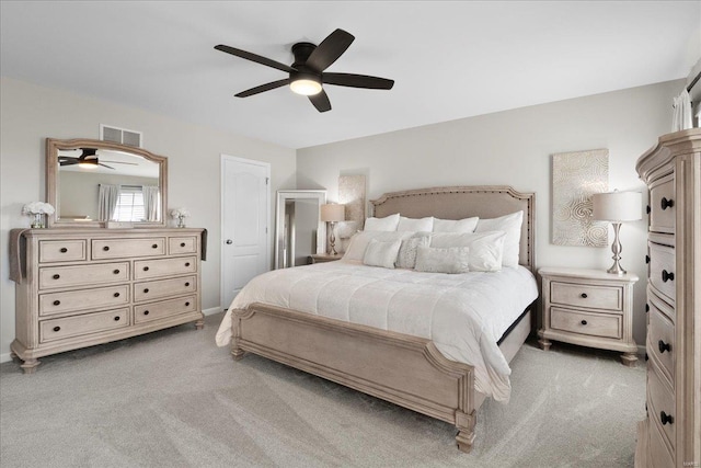 bedroom with light carpet, visible vents, baseboards, and ceiling fan