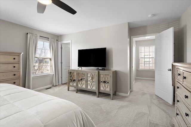 bedroom with light carpet, visible vents, multiple windows, and baseboards