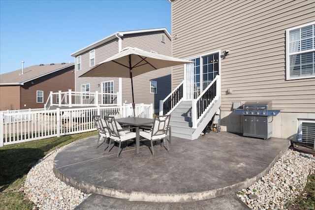 view of patio with grilling area, outdoor dining area, and fence