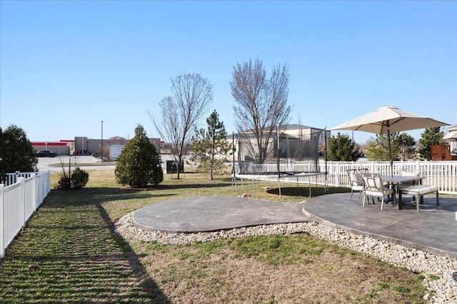 view of yard with a trampoline, a patio area, and fence