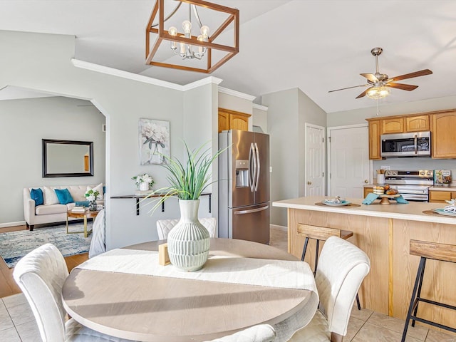 dining room featuring baseboards, light tile patterned flooring, arched walkways, ceiling fan, and vaulted ceiling