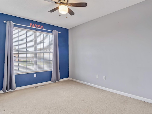 unfurnished room featuring visible vents, carpet floors, baseboards, and a ceiling fan