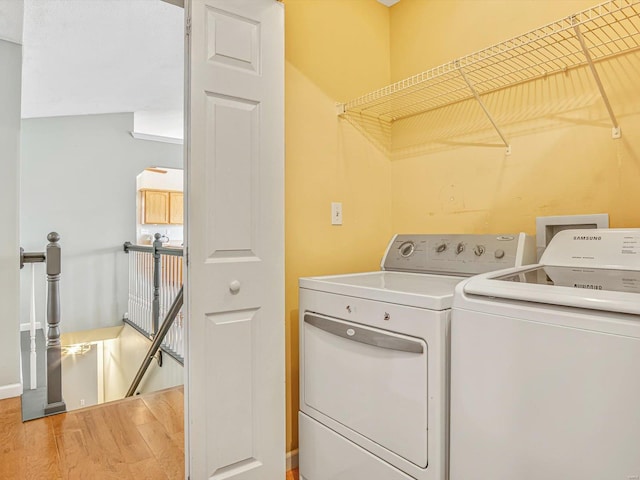 laundry room featuring wood finished floors and washer and clothes dryer