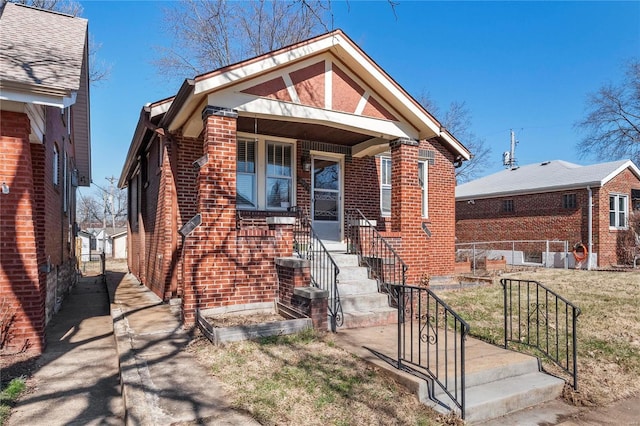 view of front of home featuring brick siding and fence