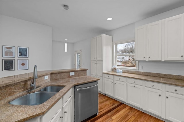 kitchen with dishwasher, light wood-style flooring, white cabinets, and a sink