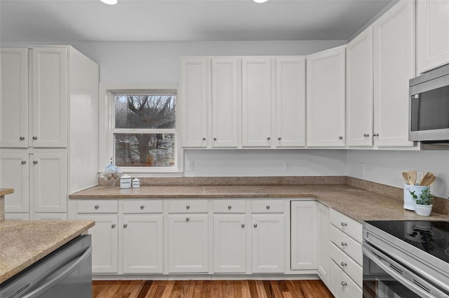 kitchen with stainless steel appliances, white cabinets, and light wood finished floors