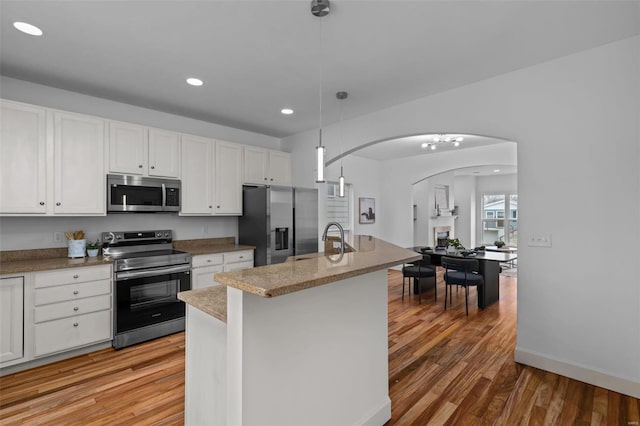 kitchen featuring white cabinetry, light wood finished floors, appliances with stainless steel finishes, and a sink