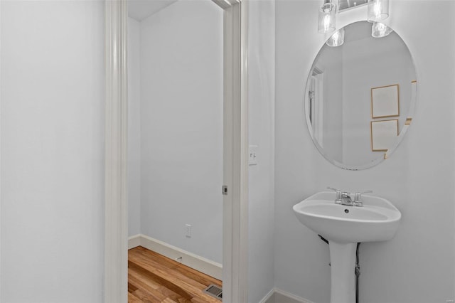 bathroom featuring wood finished floors, visible vents, and baseboards