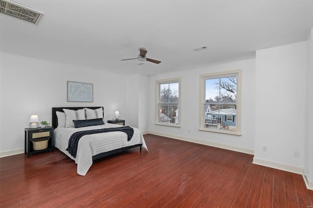 bedroom featuring visible vents, baseboards, and wood finished floors