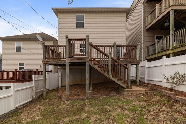 rear view of property with stairs, a deck, and fence