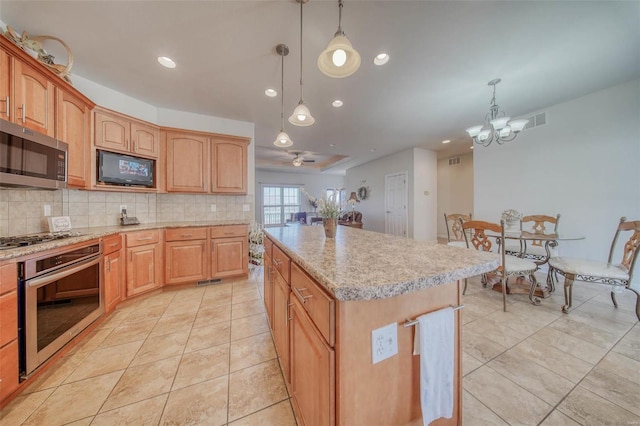 kitchen featuring stainless steel appliances, backsplash, pendant lighting, and a center island