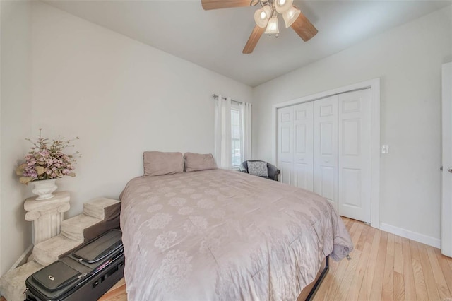 bedroom featuring light wood finished floors, baseboards, a closet, and a ceiling fan