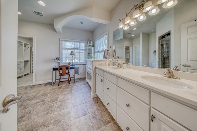 full bath with double vanity, visible vents, baseboards, and a sink