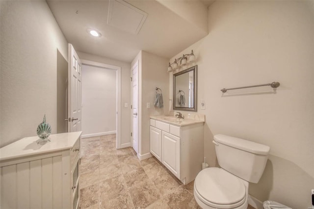 bathroom featuring vanity, toilet, and baseboards