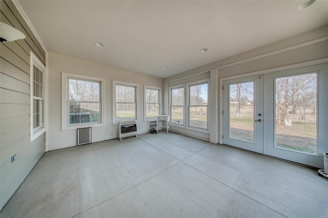 unfurnished sunroom featuring heating unit and french doors