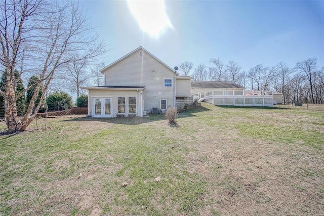 back of house featuring french doors, central AC, a yard, and fence