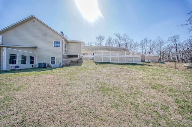 back of house with a yard, fence, and central AC