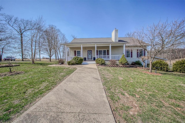 view of front facade featuring covered porch, a chimney, and a front yard