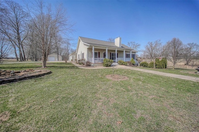 view of front of home featuring a front yard, a porch, a chimney, an outdoor structure, and a detached garage