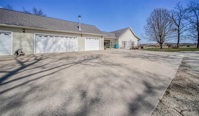 view of side of property featuring an attached garage and driveway