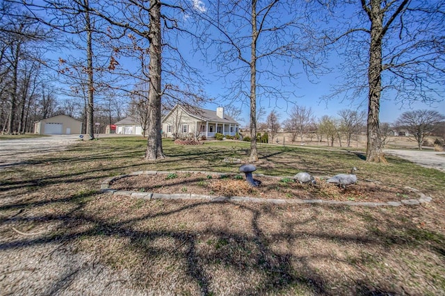 view of yard with covered porch and a garage