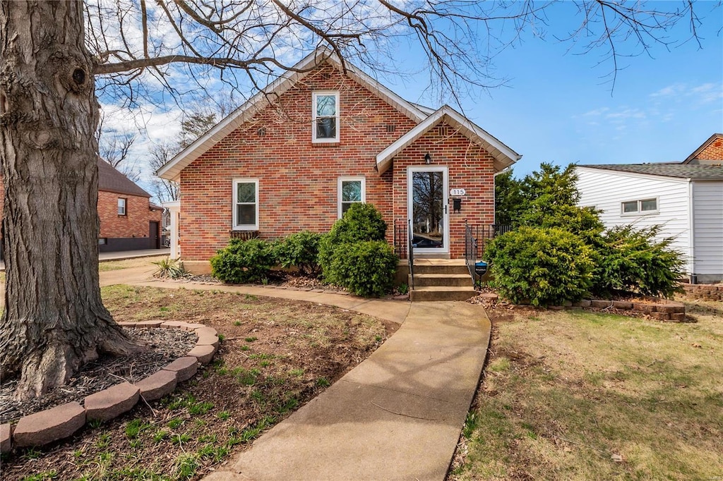 view of front of house with brick siding and a front lawn