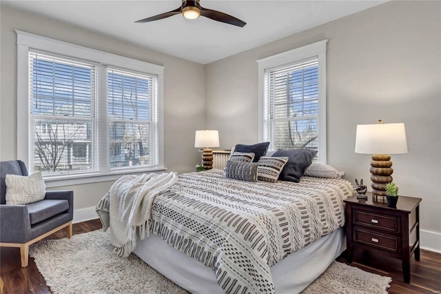 bedroom featuring baseboards, multiple windows, and wood finished floors