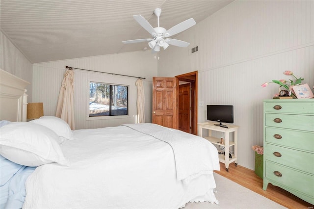 bedroom featuring light wood-type flooring, lofted ceiling, visible vents, and ceiling fan