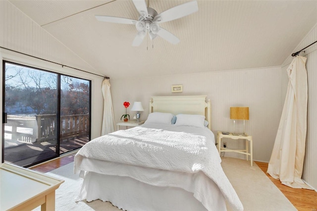 bedroom with a ceiling fan, vaulted ceiling, wood finished floors, and access to exterior