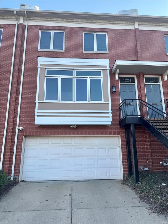 view of front of property featuring concrete driveway, a garage, and brick siding