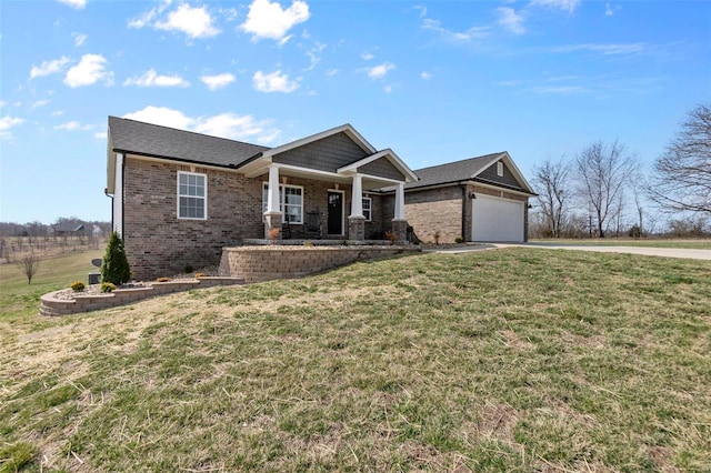 view of front of home featuring a front yard, brick siding, a porch, and driveway