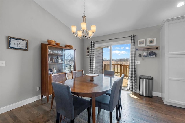 dining room featuring a chandelier, dark wood-style floors, baseboards, and lofted ceiling