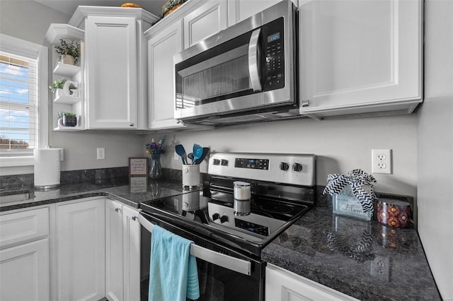 kitchen with open shelves, a sink, white cabinetry, dark stone counters, and appliances with stainless steel finishes