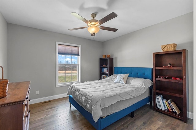 bedroom featuring visible vents, a ceiling fan, baseboards, and hardwood / wood-style floors