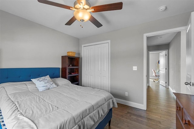 bedroom featuring a closet, baseboards, wood finished floors, and a ceiling fan