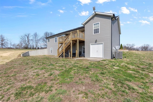 back of house with a patio, central AC unit, a wooden deck, stairs, and a lawn