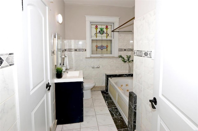 bathroom with toilet, marble finish floor, a jetted tub, tile walls, and vanity