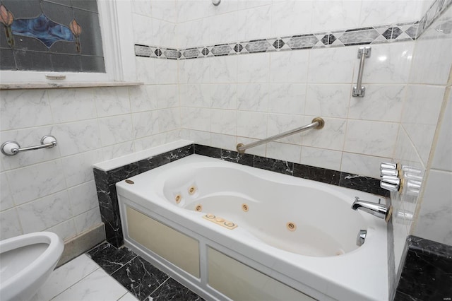 full bath featuring tile walls, a tub with jets, and marble finish floor