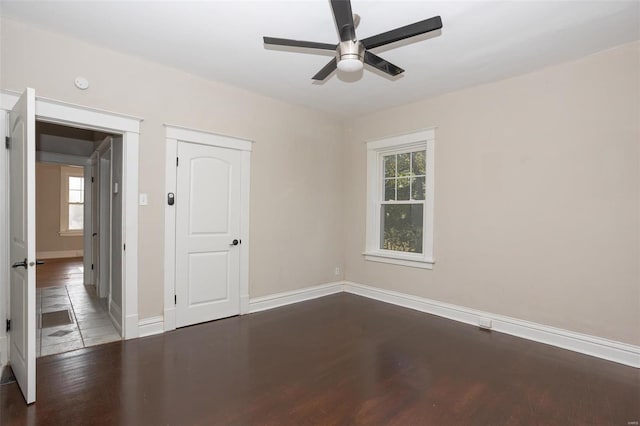 unfurnished room featuring a ceiling fan, wood finished floors, and baseboards