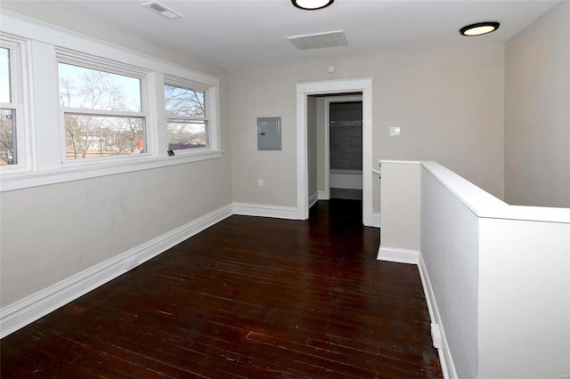 corridor with an upstairs landing, visible vents, wood-type flooring, and baseboards