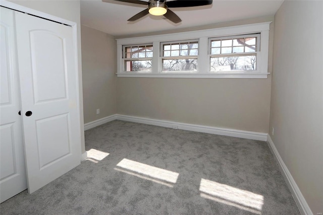 unfurnished bedroom with baseboards, a closet, multiple windows, and carpet floors