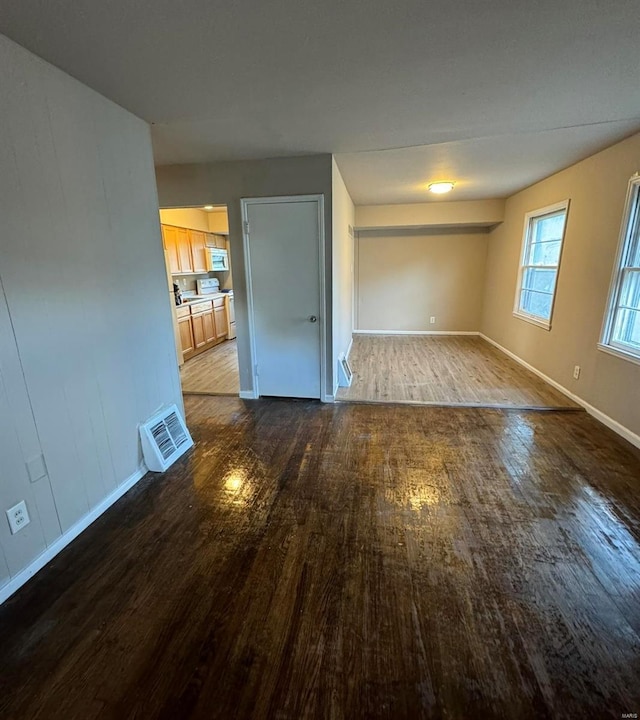 empty room with visible vents, baseboards, and wood finished floors