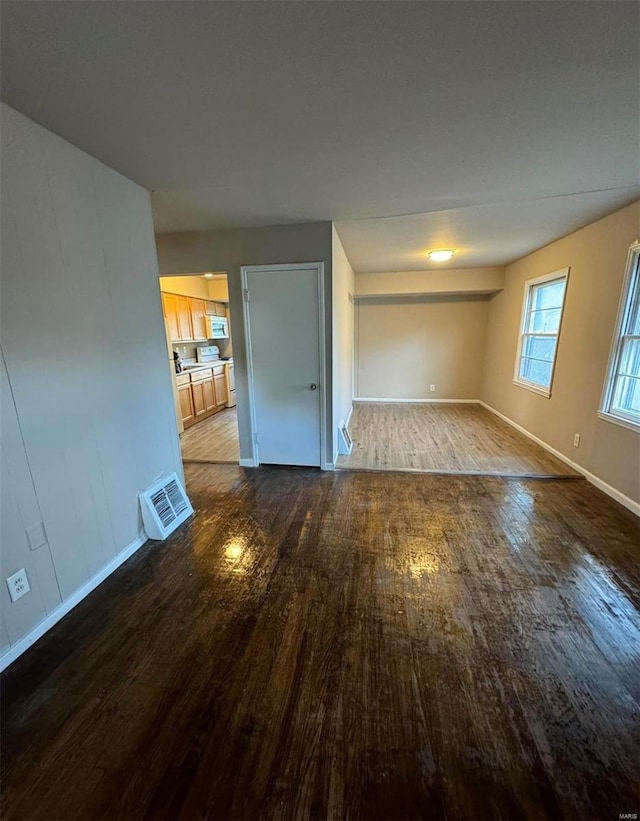 interior space with wood finished floors, visible vents, and baseboards