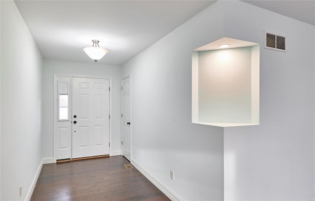 foyer with dark wood finished floors, baseboards, and visible vents