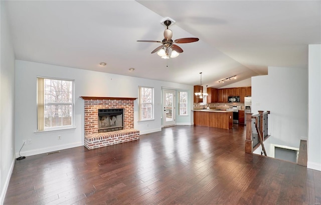 living area with dark wood-style floors, a healthy amount of sunlight, ceiling fan, and vaulted ceiling