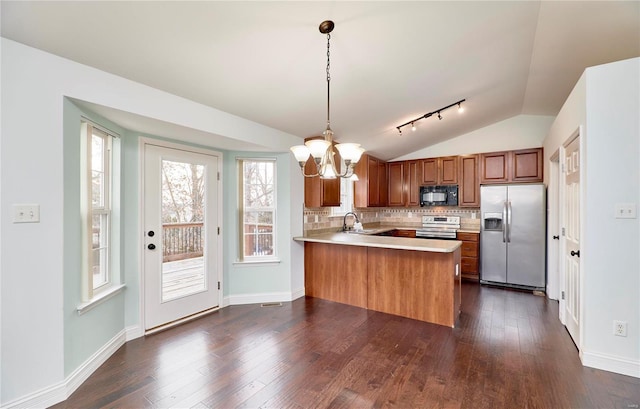 kitchen with a sink, dark wood-style floors, stainless steel appliances, an inviting chandelier, and a peninsula