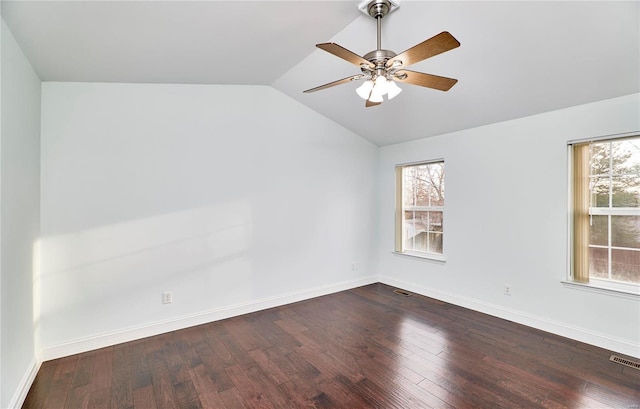 spare room with visible vents, lofted ceiling, dark wood-type flooring, and baseboards