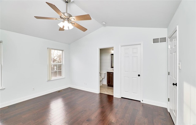 unfurnished bedroom with dark wood-type flooring, baseboards, visible vents, and vaulted ceiling