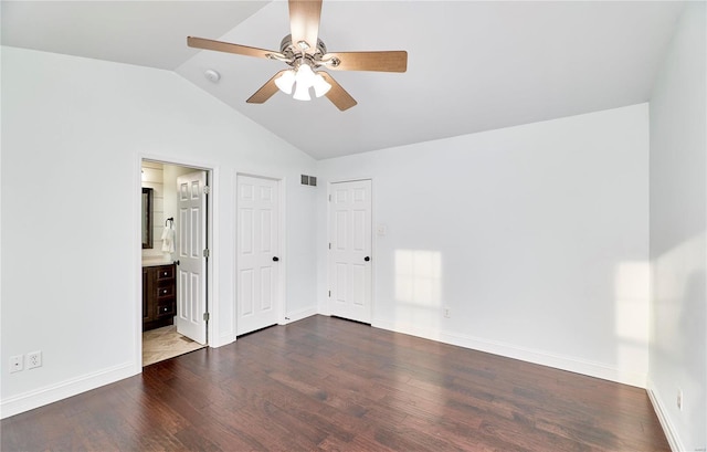 unfurnished bedroom with lofted ceiling, dark wood-style floors, visible vents, and baseboards